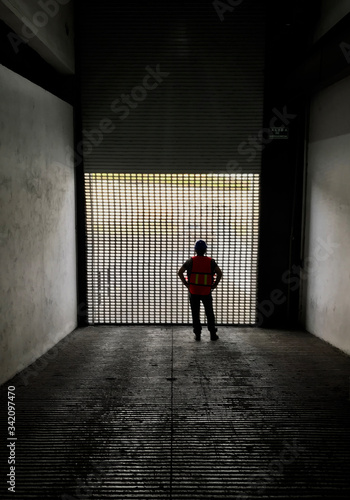 silhouette of a man in a corridor with an industrial hat