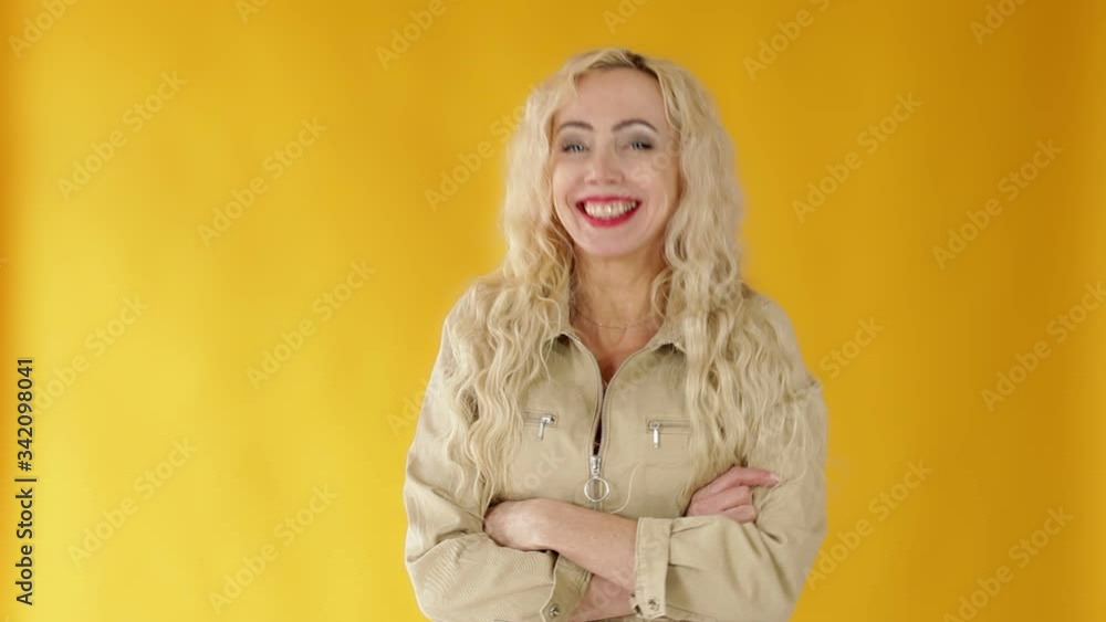 Portrait of a joyful and cheerful cute European curly-haired blonde woman who jokes cheerfully, entertains the conversation Portrait of a joyful and cheerful cute European curly-haired blonde woman who jokes cheerfully, entertains the conversation