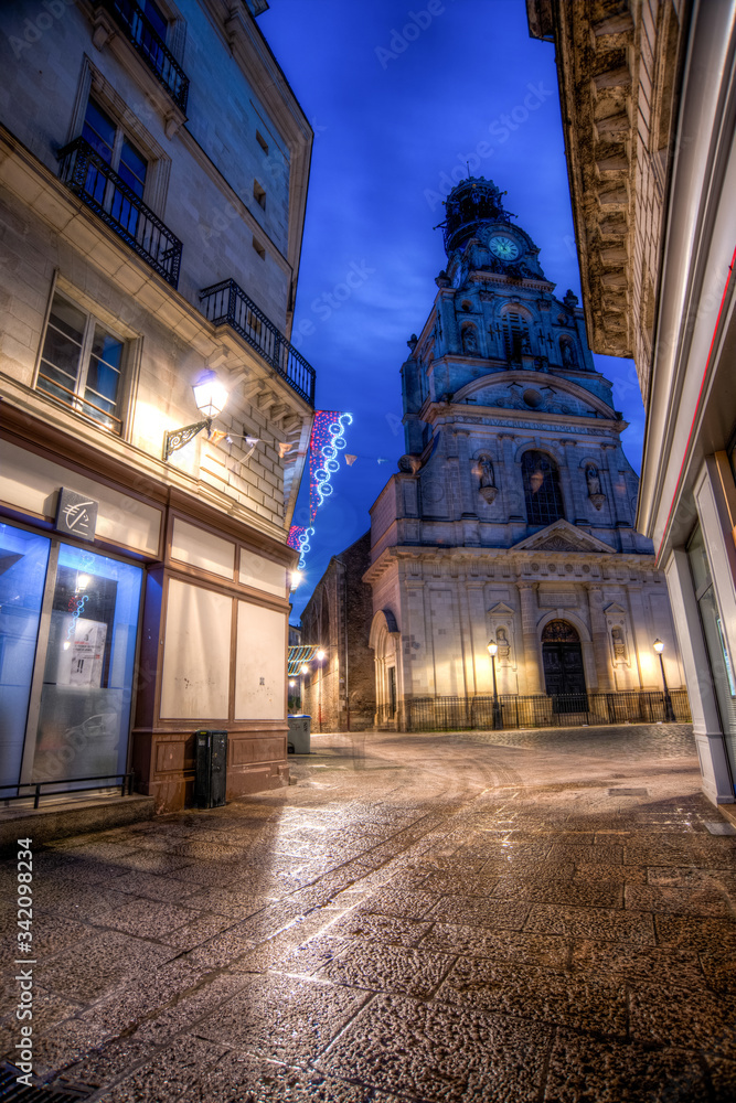 Naklejka premium rue de nuit vide avec bâtiment du XIXe siècle et église de nuit avec des décors de noël à Nantes en France