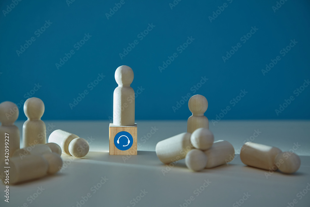 Obraz premium Wooden figure on cube, headset sign. Customer support service. Call centre operator, customers miniatures, copy space