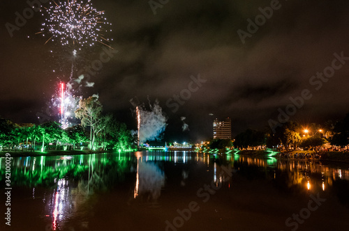 Colorful fireworks over Bebedouro city (SP state - Brazil) at night with reflection in the water