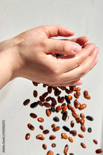 Beans are strewed through the hands of a woman.