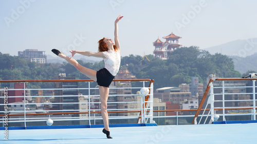 Ballerina is dancing a graceful dance, a light flying dancer, flexible slender figure, long beautiful legs by model. girl against  background of Asian city in Taiwan. classic choreography, performer