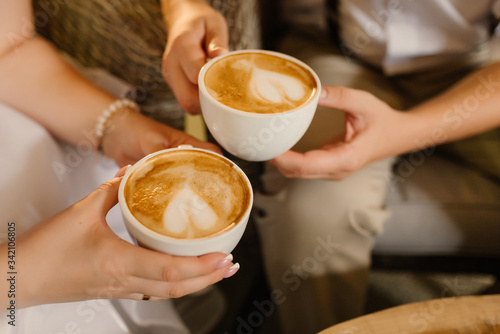 Female, male hands hold cups with coffee close-up. Coffee time concept.