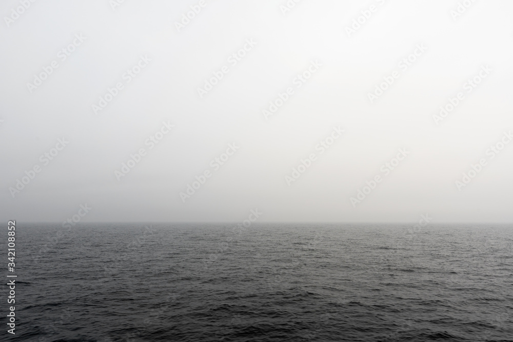 Seascape. Fog in the sea. The ship follows in the fog. View from the navigation bridge. Navigator's watch service on a cargo ship.