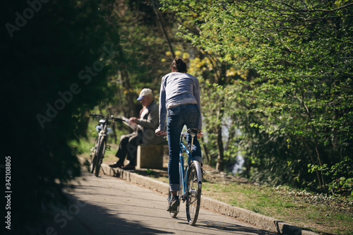 A woman rides a bicycle. Back view.