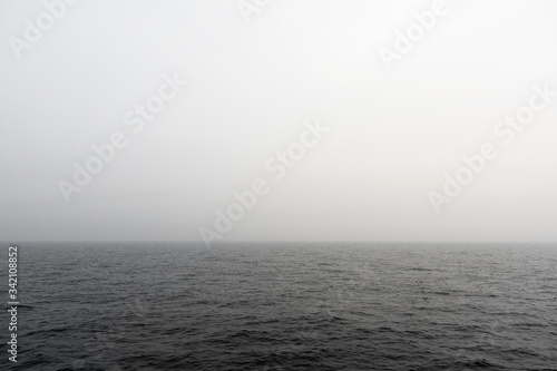 Seascape. Fog in the sea. The ship follows in the fog. View from the navigation bridge. Navigator's watch service on a cargo ship.