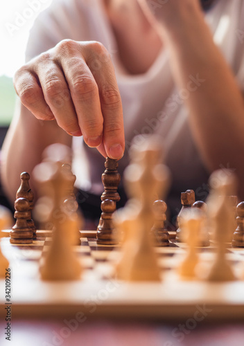 Pensive woman plays chess