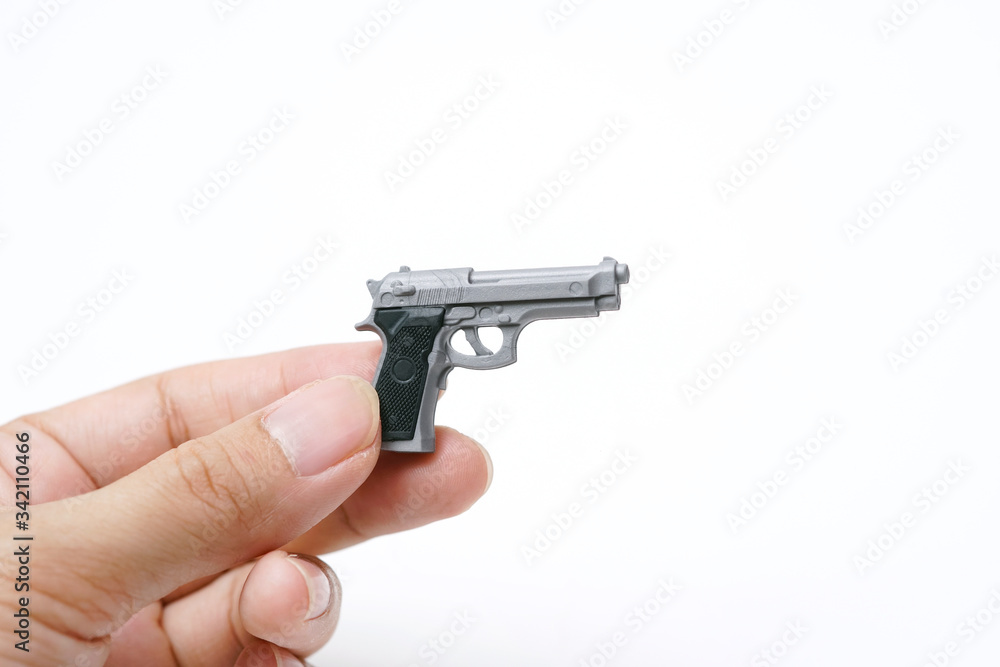 Hand Holding Tiny Model Automatic Gun on White Background                                                               