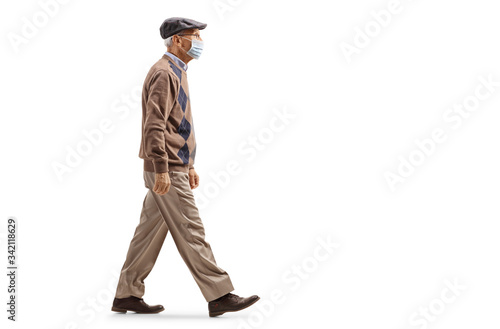 Male pensioner walking and wearing a protective medical face mask
