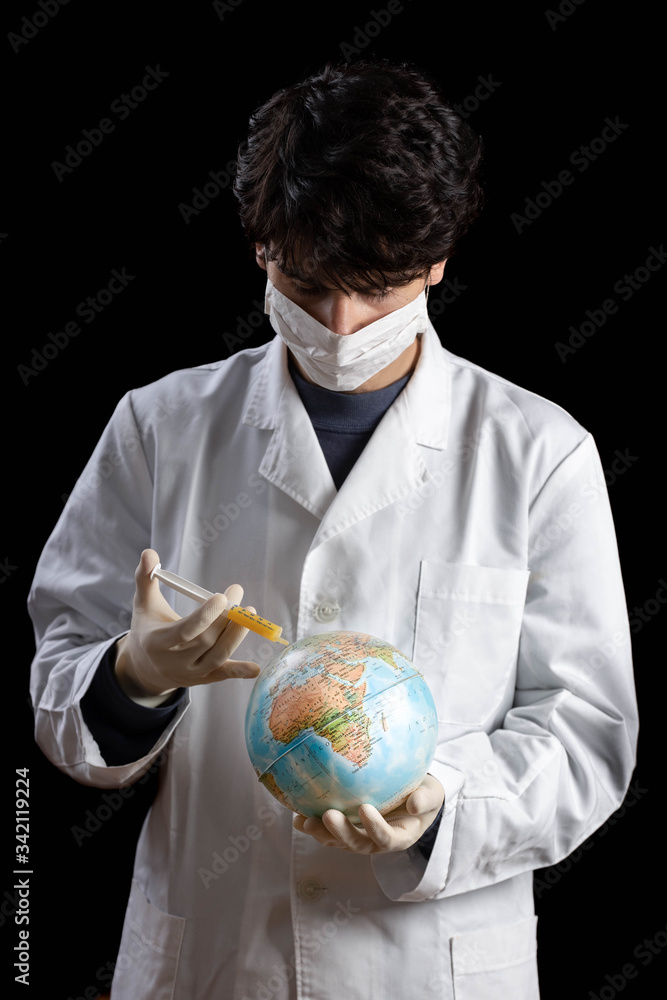 Doctor with face mask looking down healing a world globe Doctor with face mask looking down healing a world globe