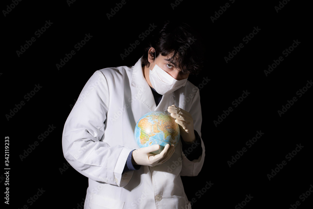 Young doctor with face mask stroking a world globe Young doctor with face mask stroking a world globe