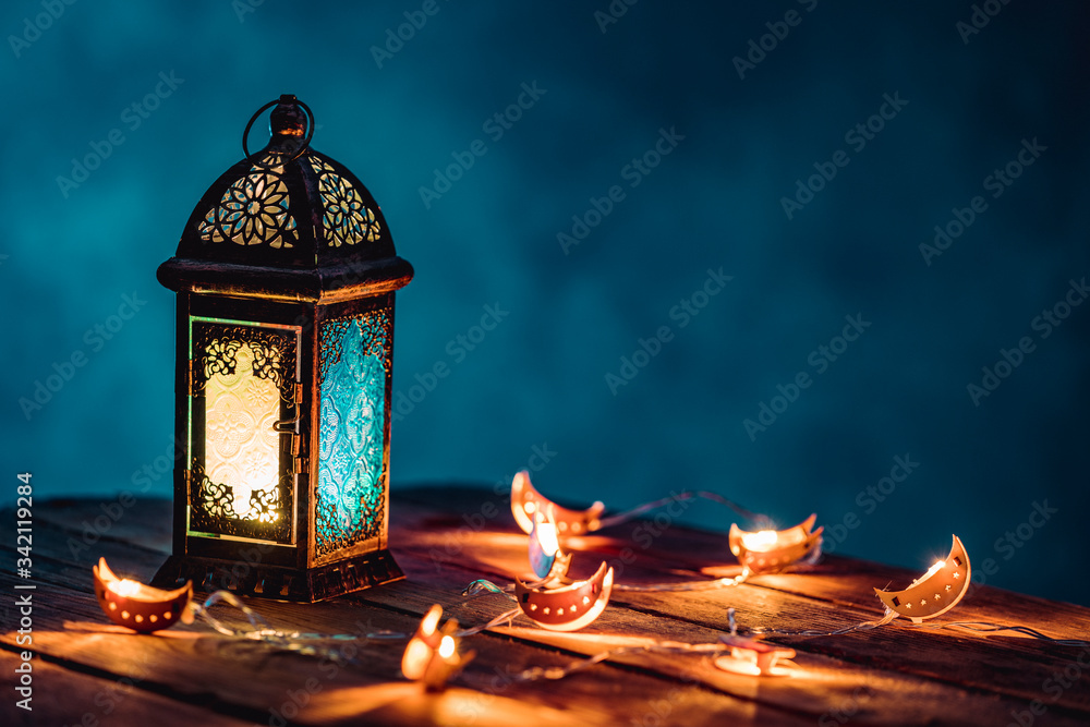 Ramadan Lantern with Colorful Light Glowing at Night and Glittering with Bokeh Lights on Ground. Festive Greeting Card, Invitation for Muslim Holy Month Ramadan Kareem. Blue Dark background - obrazy, fototapety, plakaty 