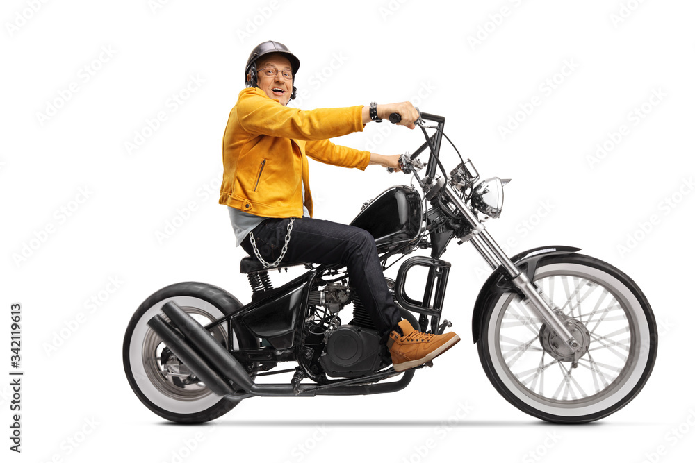 Mature biker in a yellow leather jacket riding  a chopper motorbike