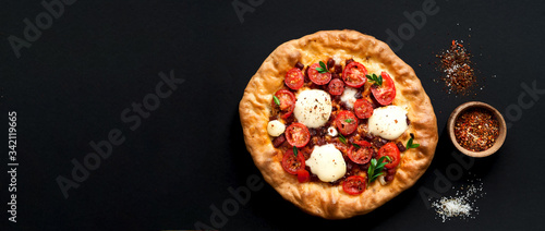 Homemade pizza on dark background. The concept of traditional Italian food. Stay at home. Close-up