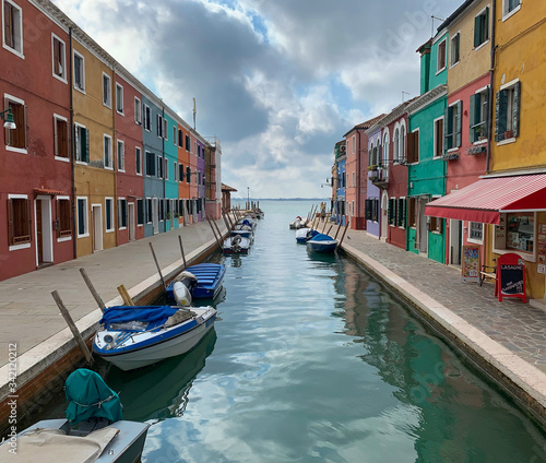 Canal with small boats in Burano, Italy