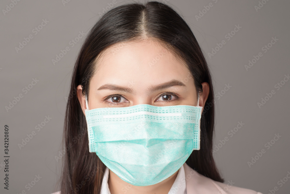 close up portrait of business woman with surgical mask on gray background close up portrait of business woman with surgical mask on gray background