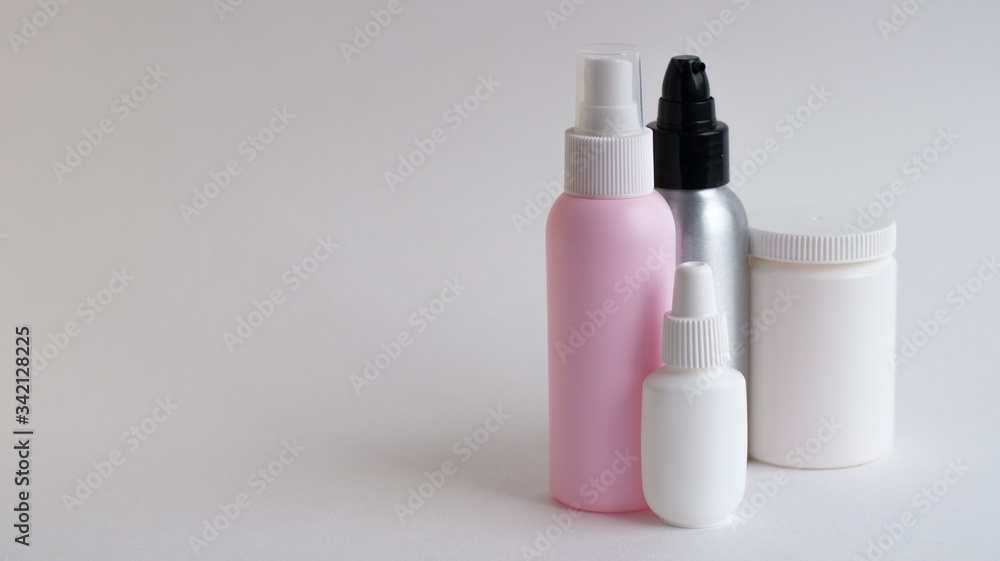 Bottles with tablets in white, pink, gray on a gray background. Copy space Bottles with tablets in white, pink, gray on a gray background. Copy space