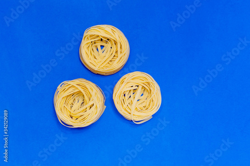 Three pasta raw yellow nests isolated photo