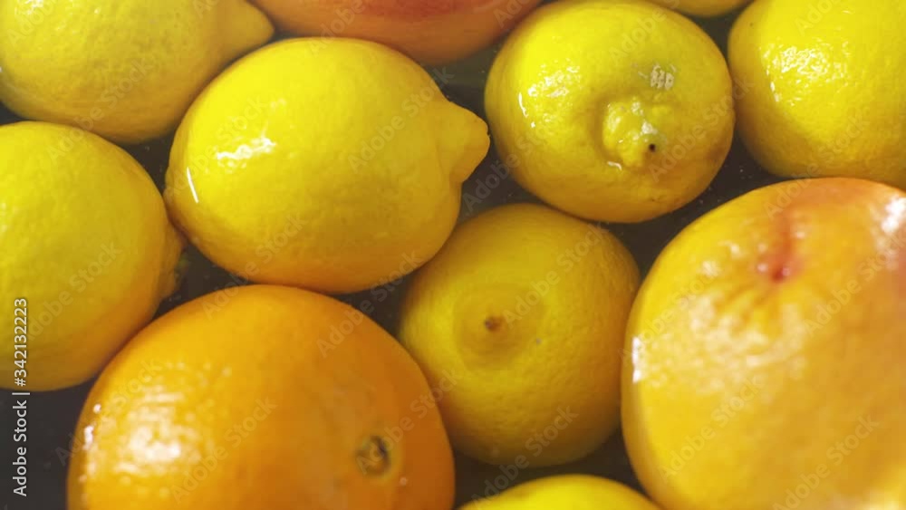 Close-up of citrus fruits in the water. Lemons, grapefruits and oranges. Cooking fruits before eating. Healthy lifestyle. Coronavirus protection. Close-up of citrus fruits in the water. Lemons, grapefruits and oranges. Cooking fruits before eating. Healthy lifestyle. Coronavirus protection.