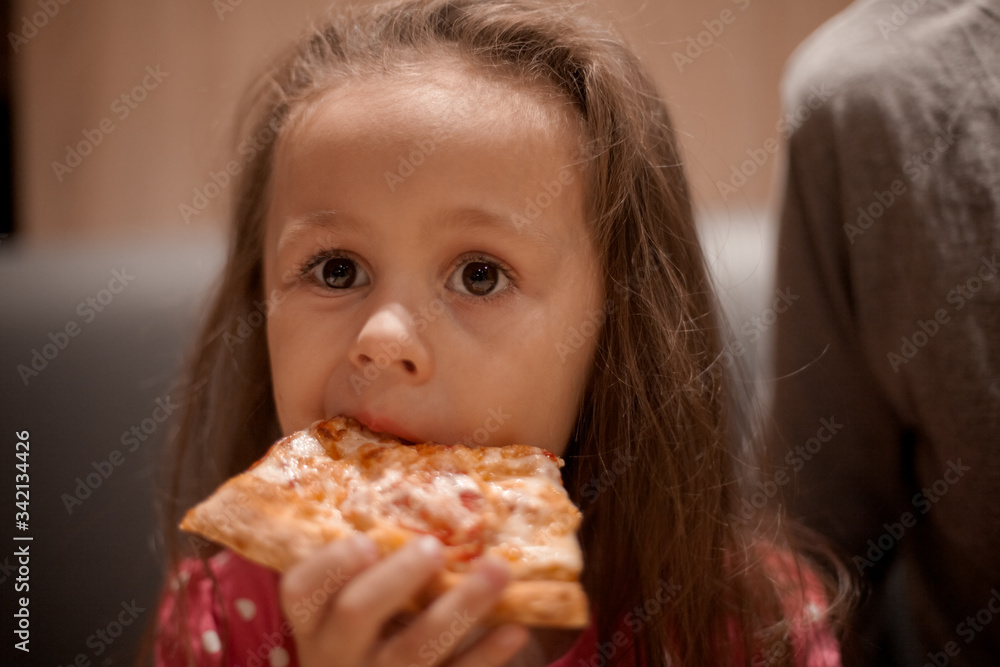 father feeding his cute daughter with pizza