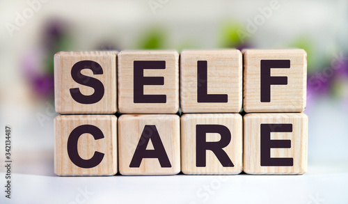 Konstfotografi SELF CARE - text on wooden cubes on a floral background with tulip buds