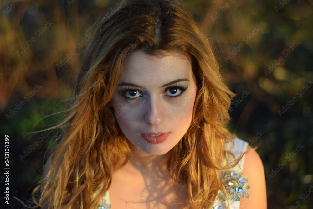 Naklejka premium Beautiful girl with charming look with a white wedding dress in the forest