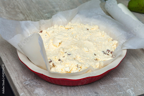 raw curd dough in a round ceramic baking dish.