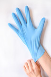 A girl puts on blue gloves