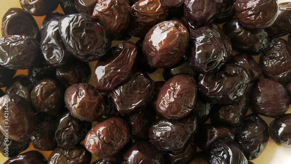 Black smoked olives. Marinated olives close-up. Food background. Selective focus image. Slow motion. Black smoked olives. Marinated olives close-up. Food background. Selective focus image. Slow motion.