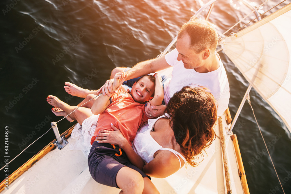 Happy family with son resting on a sailing yacht