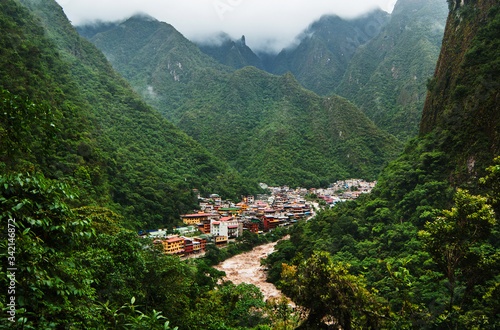 The Urubamba River flowing through the town of Aguas Calientes and the green Andes mountains, Cusco, Peru, South America photo