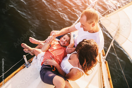 Happy family with son resting on a sailing yacht © VlaDee