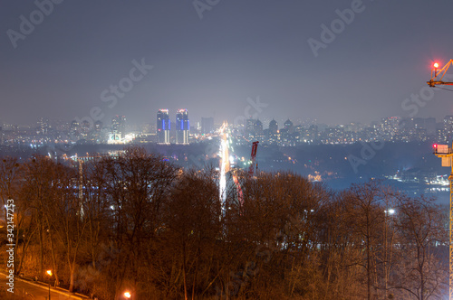 Night view of "Metro" bridge from right bank of Dnieper river in Kyiv, Ukraine