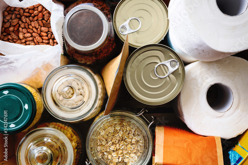 Close up of non-perishable food, canned goods and toilet paper. Overhead view.
