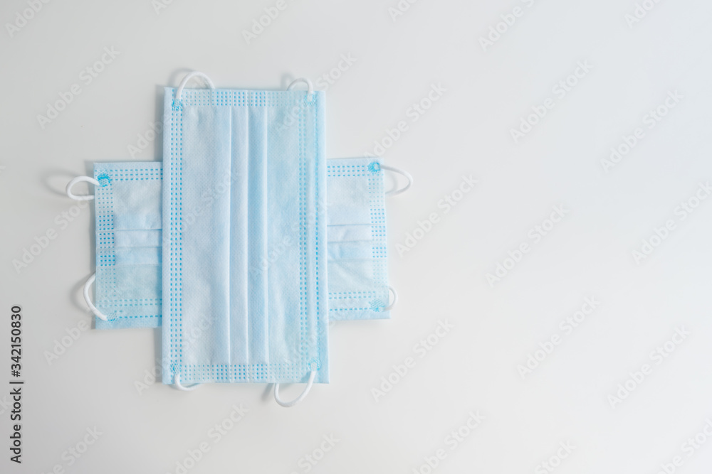 The cross of blue medical protective face masks with copy space for text. Protection measures against coronavirus concept The cross of blue medical protective face masks with copy space for text. Protection measures against coronavirus concept