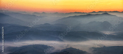 Schilderij op canvas silhouettes of foggy mountains