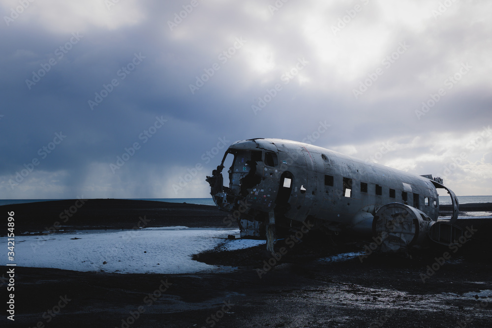 Abandoned plane wreck on Sólheimasandur with moody sky, Iceland Abandoned plane wreck on Sólheimasandur with moody sky, Iceland