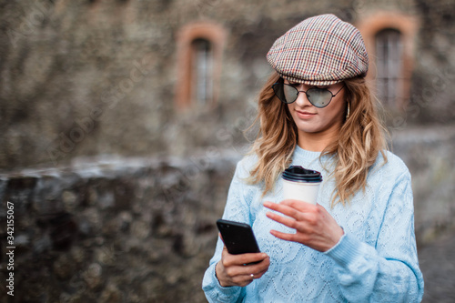 Image of beautiful stylish woman. Summer day and holding mobile phone. Street style. Model. Summer girl.