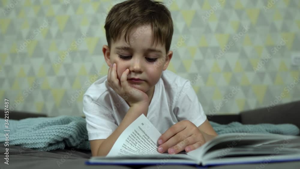 Little boy lying on the bed and reading a book. Little boy lying on the bed and reading a book.