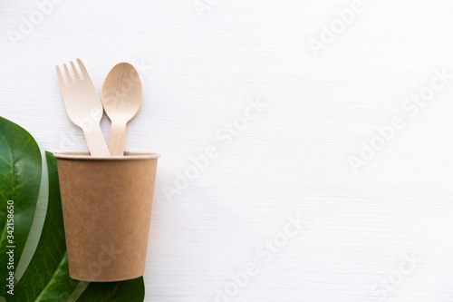 eco friendly disposable kitchenware utensils on white background. wooden forks and spoons in paper cup. ecology, zero waste concept. top view. flat lay.