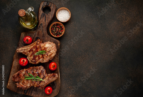 two grilled beef steaks with spices on a stone background with copy space for your text