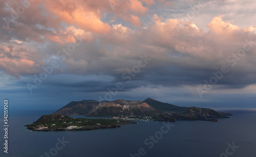 Panorama view to volcano island Vulcano, with dramatic clouds in the sky during sunset, Sicily Italy.