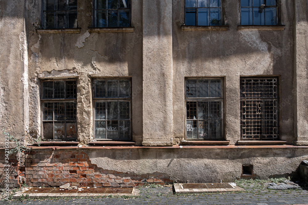 Damaged wall of an old building with windows