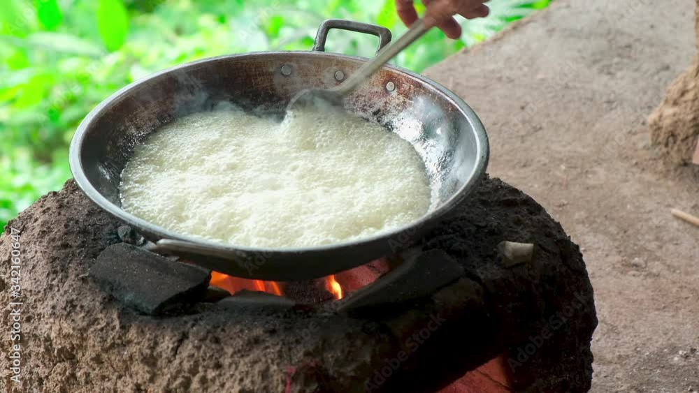 Coconut oil cooking instant hot method, at home. Heating and cooking coconut milk solution for oil extract.
old female hands mix the
boiling liquid with a scoop in a old wok
on open fire
Coconut oil cooking instant hot method, at home. Heating and cooking coconut milk solution for oil extract.
old female hands mix the
boiling liquid with a scoop in a old wok
on open fire