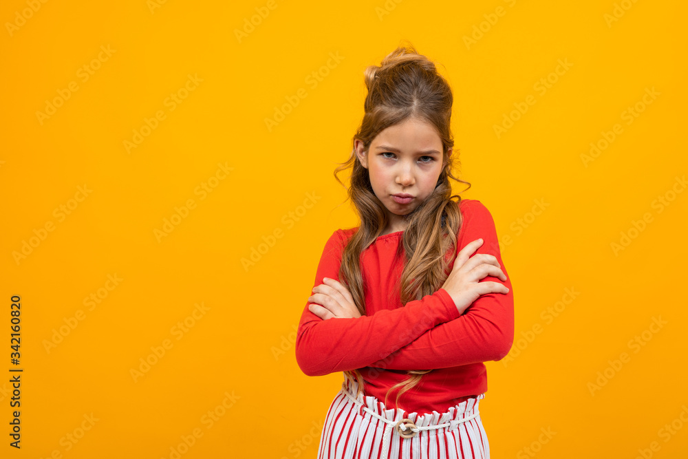 offended teenager girl crossed her arms on a yellow background with copy space offended teenager girl crossed her arms on a yellow background with copy space