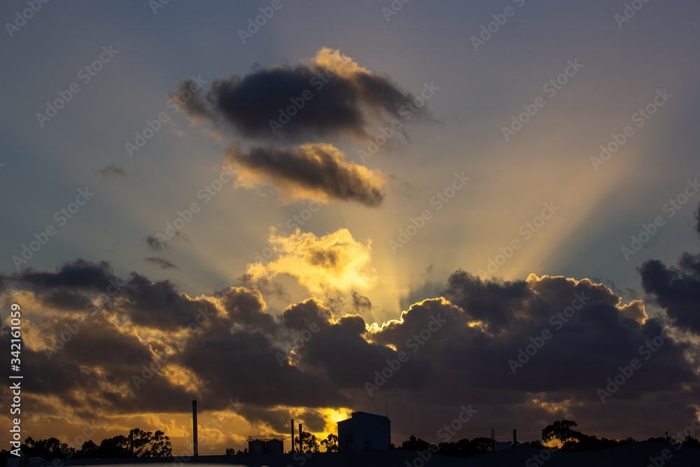 sunset rays behind the clouds