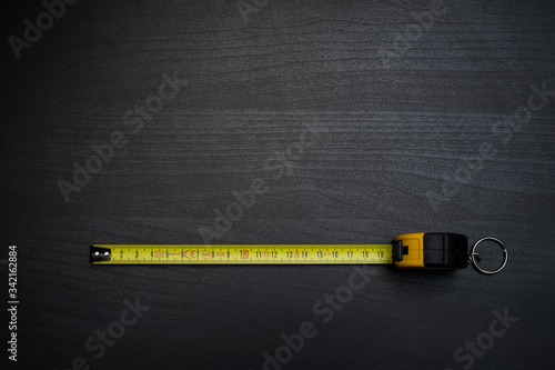measuring tape on dark wooden table