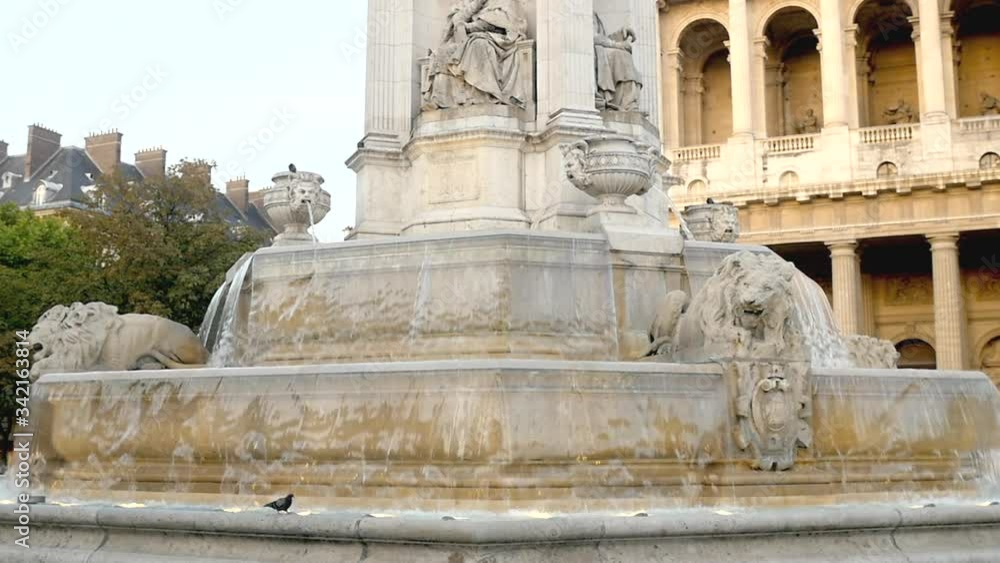 Classical French fountain and church on sunset light in Paris Classical French fountain and church on sunset light in Paris