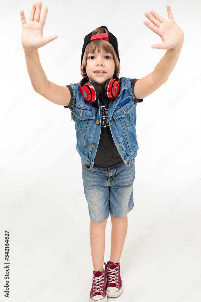 european boy with red headphones pulls his hands to the camera on a white background. european boy with red headphones pulls his hands to the camera on a white background.
